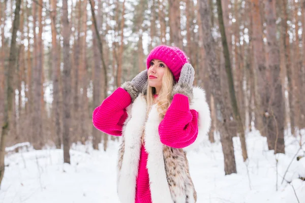 Природа, мода и концепция зимы - симпатичная молодая женщина в розовой теплой куртке в заснеженном парке — стоковое фото