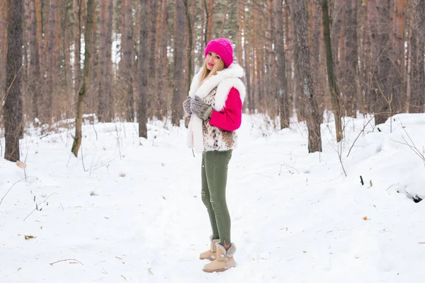 Divat, és az emberek koncepció - vonzó fiatal nő áll a rózsaszín meleg dzseki téli havas Park — Stock Fotó