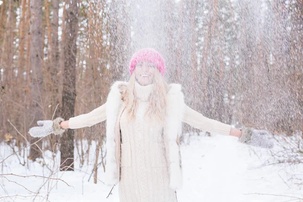 Ritratto di giovane donna che getta la neve. Ragazza sorridente che cammina in un parco invernale e si diverte in una fredda giornata di sole all'aperto — Foto Stock