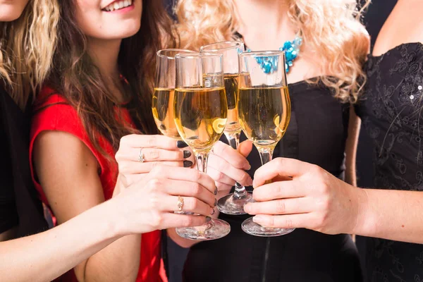 Festa, capodanno e concetto di persone - Primo piano di giovani donne che si accarezzano bicchieri di champagne alla festa Immagini Stock Royalty Free