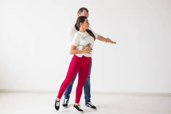Gelukkige paar sociale dans kizomba vs bachata of salsa of zouk dansen op lichte achtergrond — Stockfoto