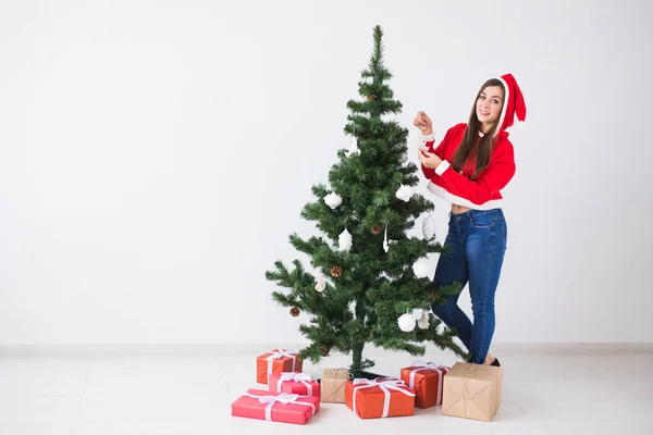 Zimní svátky a lidé koncept - milující pár závěsné ozdoby na vánoční stromeček v bílé místnosti pozadí s kopií prostor — Stock fotografie