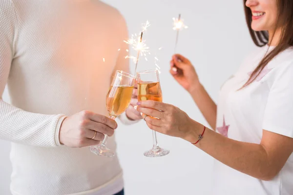 Romantic beautiful couple having date at Valentines Day. Close up of man and woman holding champagne glasses and sparklers. — Stock Photo, Image