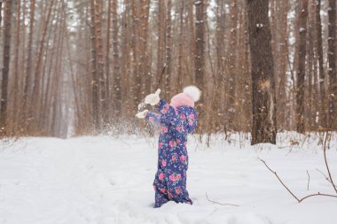 Çocukluk ve insanlar kavramı - kız çocuk kış açık havada yürüyüş ve kar kusuyor