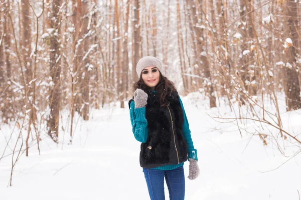 Νέοι όμορφη γυναίκα που περπατά στο χειμώνα χιονισμένο πάρκο στο ηλιόλουστη μέρα — Φωτογραφία Αρχείου