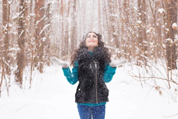 Divertimento, inverno e conceito de pessoas - Jovem atraente vestida de casaco jogando neve . — Fotografia de Stock