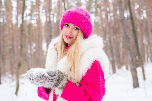 Красота, природа и люди концепция - красивая блондинка ходит в розовой шляпе и свитерах в зимнем лесу и улыбается — стоковое фото