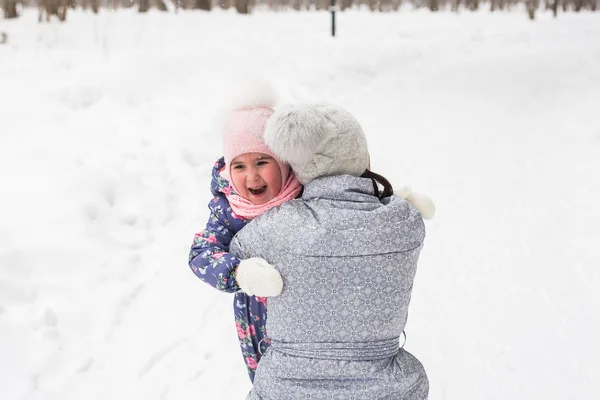 Семья, дети и природа - молодая женщина обнимает маленькую счастливую дочь в парке — стоковое фото