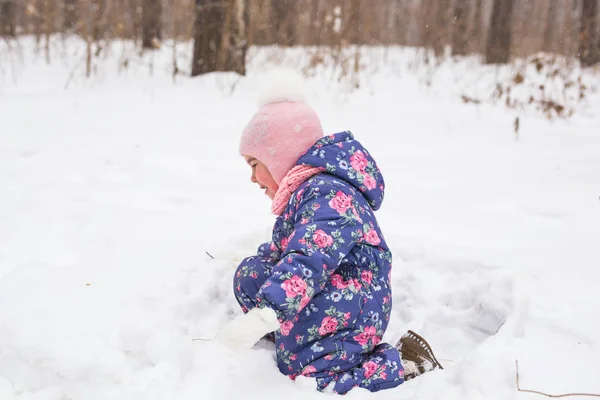 Концепция детства и природы - Очаровательный ребенок играет в зимнем парке — стоковое фото