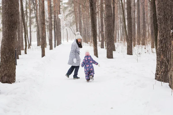 Família feliz mãe e filha criança se divertindo, brincando no inverno andar ao ar livre — Fotografia de Stock