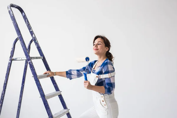 Redecoração, renovação, nova casa e conceito de pessoas - jovem mulher morena atraente fazendo reparo por si mesma — Fotografia de Stock