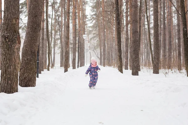 Дети, зима и природа - закройте восхитительного малыша, играющего со снегом в парке — стоковое фото