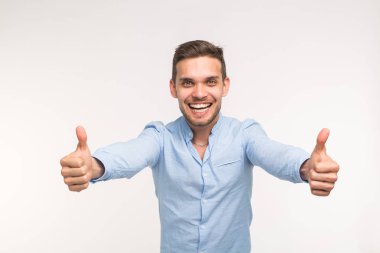 Başparmak yukarıya üstünde izole beyaz arka plan ile şık yakışıklı genç adam portresi