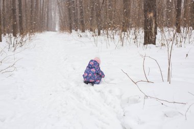Karlı Ormanda çalışan çocuk. Açık havada oynayan yürümeye başlayan çocuk. Çocuk oyun karlı Park.