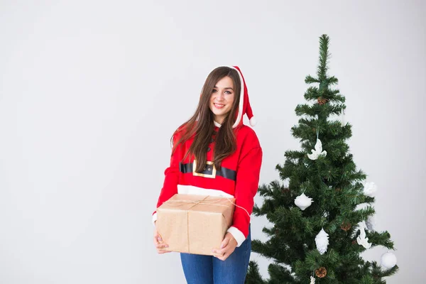 Noel Baba kostüm giyen hediye kutusu tutan genç neşeli kadın. Noel ağacı arka plan kopya alanı ile — Stok fotoğraf
