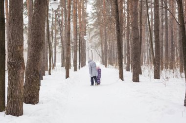 Kış, insanlar kavramı-anne ile kızı arkadan görünüm kış ormandaki dolaşıyor