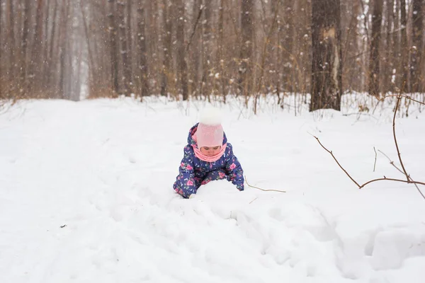 Ребенок бегает в снежном лесу. Малыш Тоддлер играет на открытом воздухе. Детские игры в снежном парке . — стоковое фото