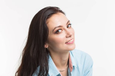 Mutlu Avrupa kadın modeli koyu saçlı. Beyaz arka plan üzerinde izole mavi gömlekli rüya gibi genç kadın portresi.