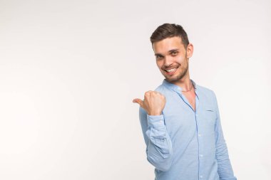 Reklam ve jest kavramı - beyaz arka plan üzerinde gülümseme ile başarılı adam boş kopya alanı üzerinde onun parmaklarıyla işaret ediyor