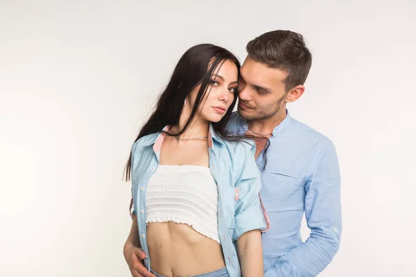 Jovem casal de amor abraçando no fundo branco — Fotografia de Stock