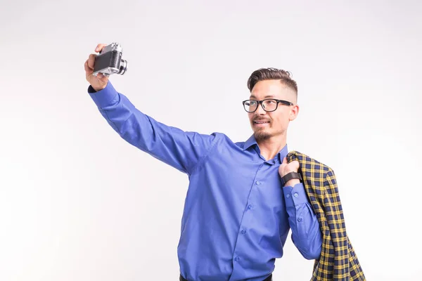 Retro camera, fotografie en mensen concept - portret van de jonge knappe man een selfies overname met witte achtergrond — Stockfoto