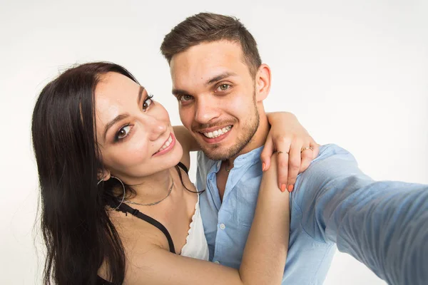 Relation et les gens concept- homme prenant selfie avec sa merveilleuse femme sur téléphone portable sur fond blanc — Photo