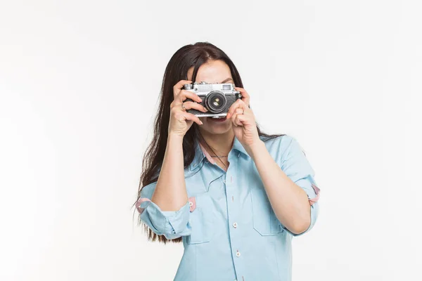 Gelukkig Europese vrouwelijke model met donker haar genieten van indoor fotoshoot. Jonge vrouw is het nemen van een foto op witte achtergrond. — Stockfoto