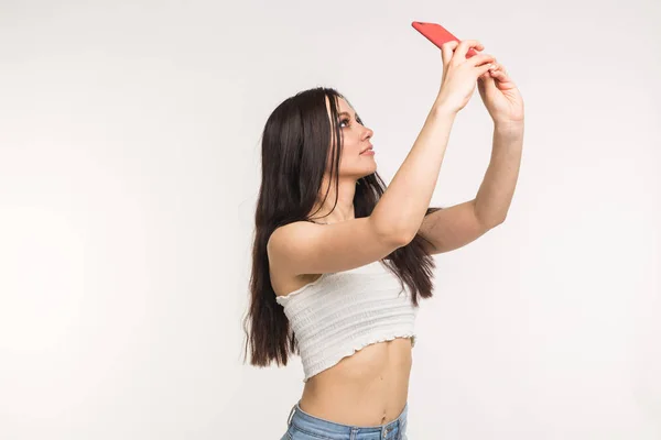 Technológia és az emberek koncepció - fiatal nő, így egy selfie fotó, és mosolygott, fehér háttér — Stock Fotó