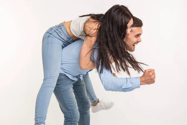 Joven macho llevando a su novia a cuestas. Están tonteando. — Foto de Stock