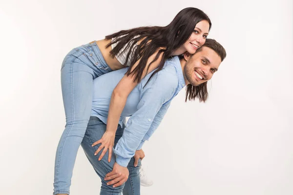 Couple posant sur fond blanc - homme drôle tenant femme sur son dos — Photo