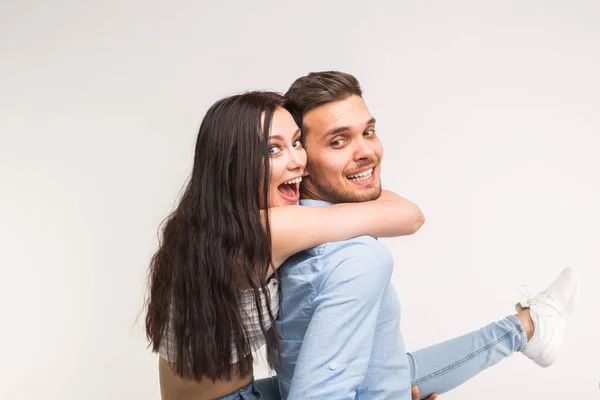 Homem jovem carregando sua namorada piggyback. Estão a brincar. — Fotografia de Stock