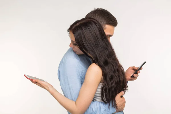 Konsep kecanduan telepon pintar - Pasangan muda menggunakan internet pada ponsel, mengabaikan satu sama lain. Mereka bosan dan sedih — Stok Foto