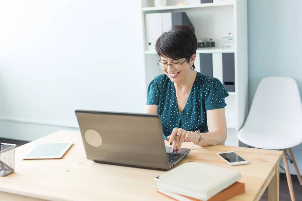 Άνθρωποι και τεχνολογία της επιχειρηματικής ιδέας - μέση ηλικία γυναίκα εργάζεται στο γραφείο με φορητό υπολογιστή — Φωτογραφία Αρχείου