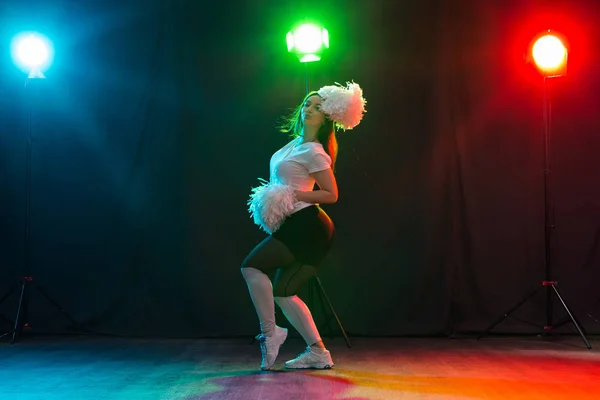 Animadora chica feliz bailando sobre fondo oscuro — Foto de Stock