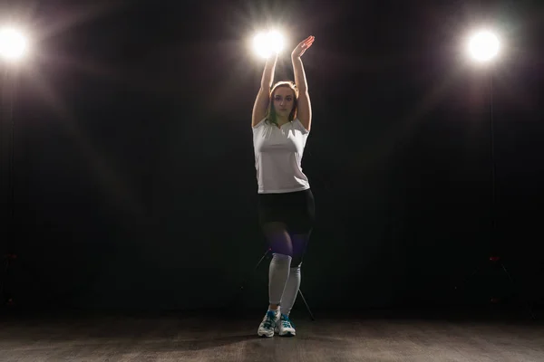 Gente y concepto de baile - Mujer joven bailando jazz funk sobre fondo oscuro — Foto de Stock