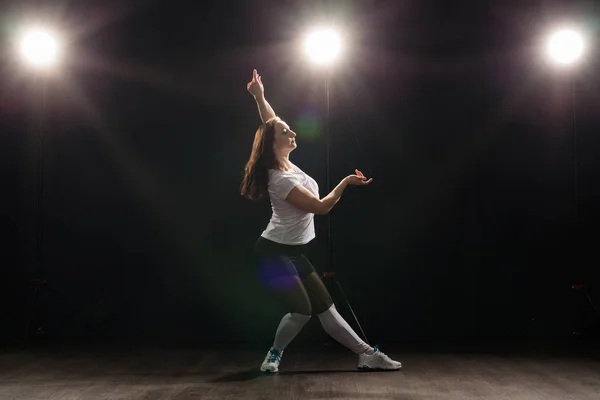 Concepto de danza, hip-hop, jazz funk y gente: una joven flexible que baila en la oscuridad bajo la luz — Foto de Stock