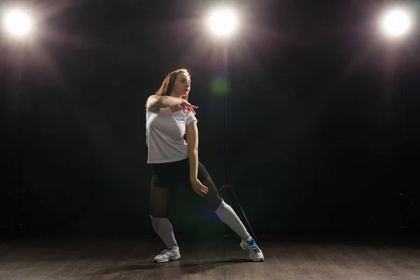 Gente y concepto de baile - Mujer joven bailando jazz funk sobre fondo oscuro — Foto de Stock