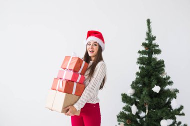 Noel ve tatil kavramı - beyaz arka plan üzerinde birçok hediyeler ile Noel Baba şapkalı kadın