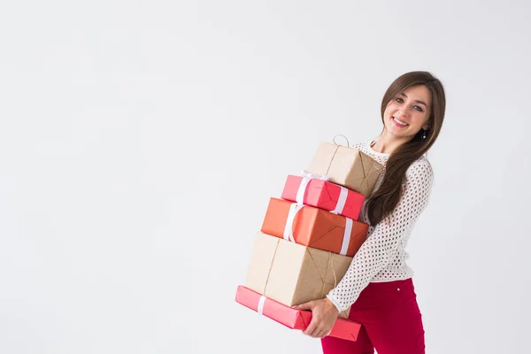 Navidad, vacaciones y regalos concepto - mujer que sostiene una gran cantidad de regalos sobre fondo blanco con espacio para copiar — Foto de Stock