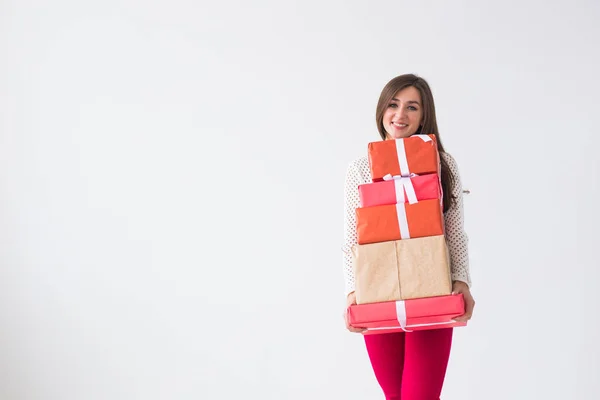 Concepto de Navidad y vacaciones - mujer joven con muchos regalos sobre fondo blanco con espacio para copiar — Foto de Stock