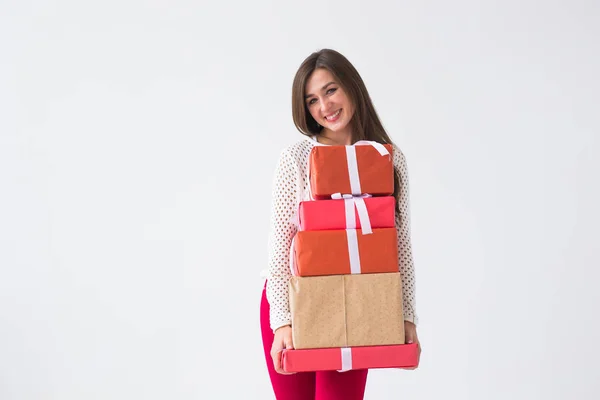 Concepto de Navidad y vacaciones: mujer joven sosteniendo una pila de cajas de regalo sobre un fondo blanco con espacio para copiar — Foto de Stock