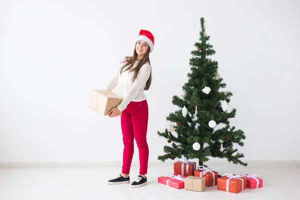 Natal, feriados e apresenta conceito - jovem mulher em santa chapéu segurando um monte de presentes no fundo branco com espaço de cópia — Fotografia de Stock