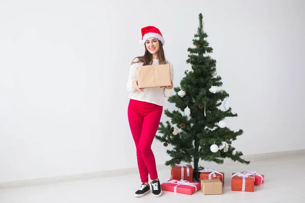 Концепция Рождества и праздников - женщина в шляпе Санты с подарочной коробкой на белом фоне — стоковое фото