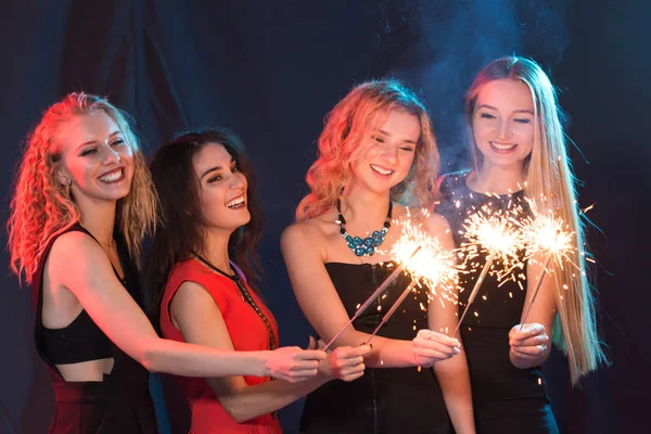 Celebrando con diversión. Grupo de mujeres jóvenes y alegres llevando bengalas. Año nuevo, vacaciones y concepto de fiesta . —  Fotos de Stock