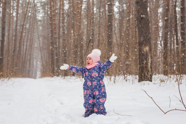 幼年期および人々 のコンセプト - 冬の屋外を歩いて、雪を投げて女の赤ちゃん — ストック写真