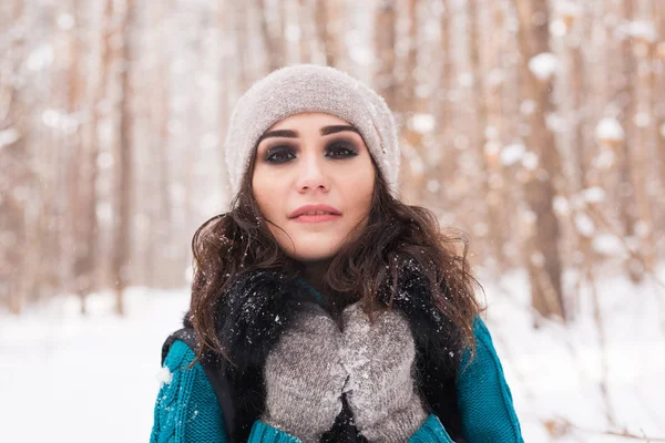 Winter, season and people concept - Portrait of young woman walking in snowy park
