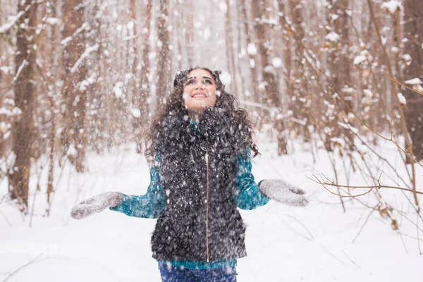 Jeune jolie femme jetant de la neige dans les airs pendant les vacances d'hiver — Photo