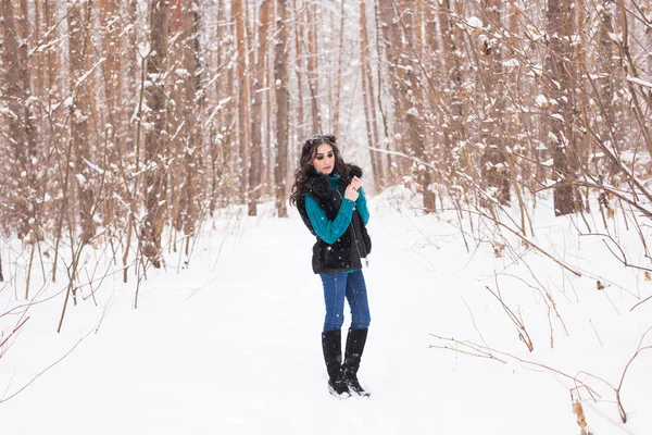 Giovane bella donna che cammina nel parco innevato invernale nella giornata di sole — Foto Stock