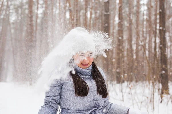 Feliz joven mujer juega con una nieve en el bosque nevado al aire libre — Foto de Stock