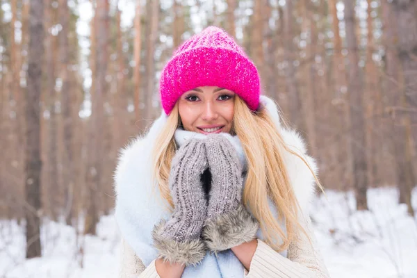雪に覆われた森の中のピンクのセーターで魅力的なブロンドの女性は笑っている人、冬美のコンセプト- — ストック写真